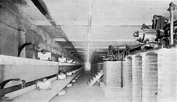 FIG. 12.  VIEW OF THIRD FLOOR SWITCHHOUSE, SHOWING AT LEFT ONE SET 2,300-VOLT BUS BARS WITH CONCRETE BARRIERS, AND AT RIGHT REMOTE-CONTROL GENERATOR AND TRANSFORMER 2,300-VOLT OIL SWITCHES.