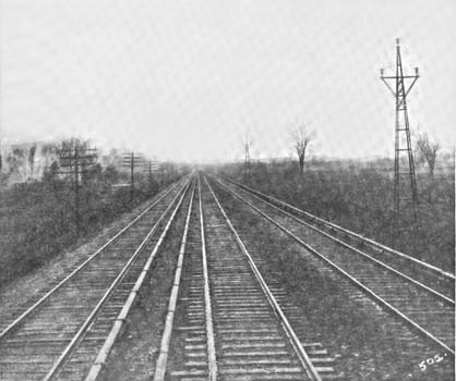 View Showing Three Track Section, Third Rail and Transmission Line Towers.