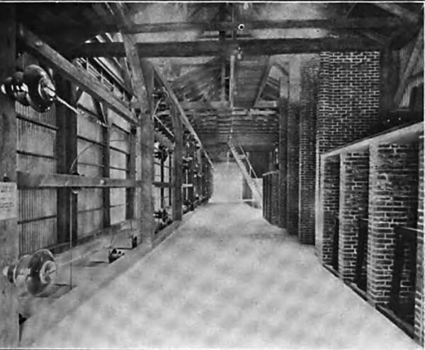 LONGITUDINAL VIEW OF THE FIFTH FLOOR OF THE SWITCH HOUSE, SHOWING HIGH TENSION SECTIONAL BUS TO LEFT, AND LIGHTNING ARRESTERS AND HIGH TENSION TRANSFORMER AND TRANSMISSION LINE SWITCH CELLS TO RIGHT.