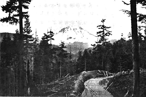 PARTIALLY CONSTRUCTED FLUME LINE SHOWING MOUNT RAINIER IN THE DISTANCE.