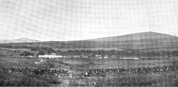 PHOTOGRAPH NO. 24. THE POWER HOUSE FROM PART WAY UP THE PIPE LINE. EL PLATANAL TO THE LEFT. THE CONSTRUCTION CAMP TO THE RIGHT. TRANSMISSION TOWERS REACHING INTO THE DISTANCE