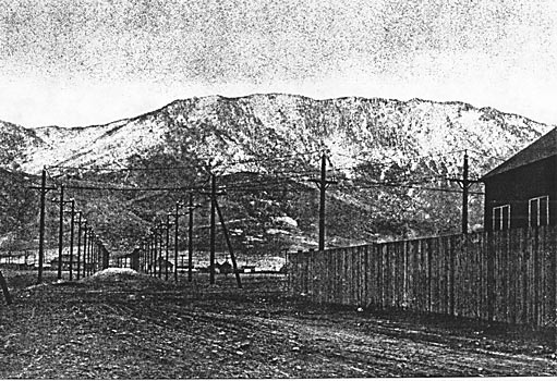 THE 57,000-VOLT DOUBLE TRANSMISSION LINE OF THE MISSOURI RIVER POWER COMPANY NEAR THE BUTTE SUB-STATION. IN THE BACKGROUND THE MAIN RANGE OF THE ROCKY MOUNTAINS CAN BE SEEN, CONSTITUTING THE CONTINENTAL DIVIDE. THE LINES ARE MADE UP OF SIX COPPER WIRES.