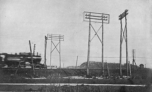 FIG. 5.  SHOWING WIRE CAGE GUARD ON THE SIDES OF AND BENEATH THE 13,000-VOLT TRANSMISSION LINES AT A PENNSYLVANIA RAILROAD CROSSING.