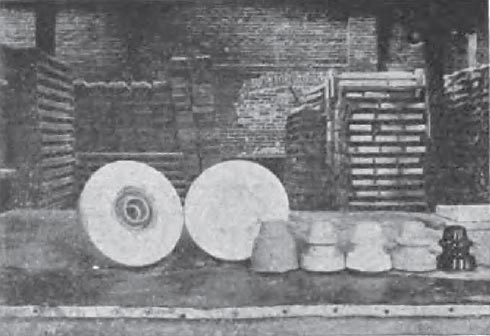 FIG. 2  HOT PRESS INSULATORS IN VARIOUS STAGES OF PRODUCTION/From left to right: 1Insulator in mould. 2Plaster of paris mould. 3Insulator removed from mould. 4Insulator trimmed. 5Insulator bone dry. 6Insulator glazed. 7Insulator fired.